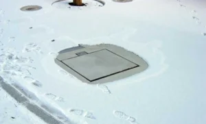 Unterflurverteiler mit Deckelheizung im Winter. Kein Eis und Schnee auf dem geschlossenen Unterflurverteiler