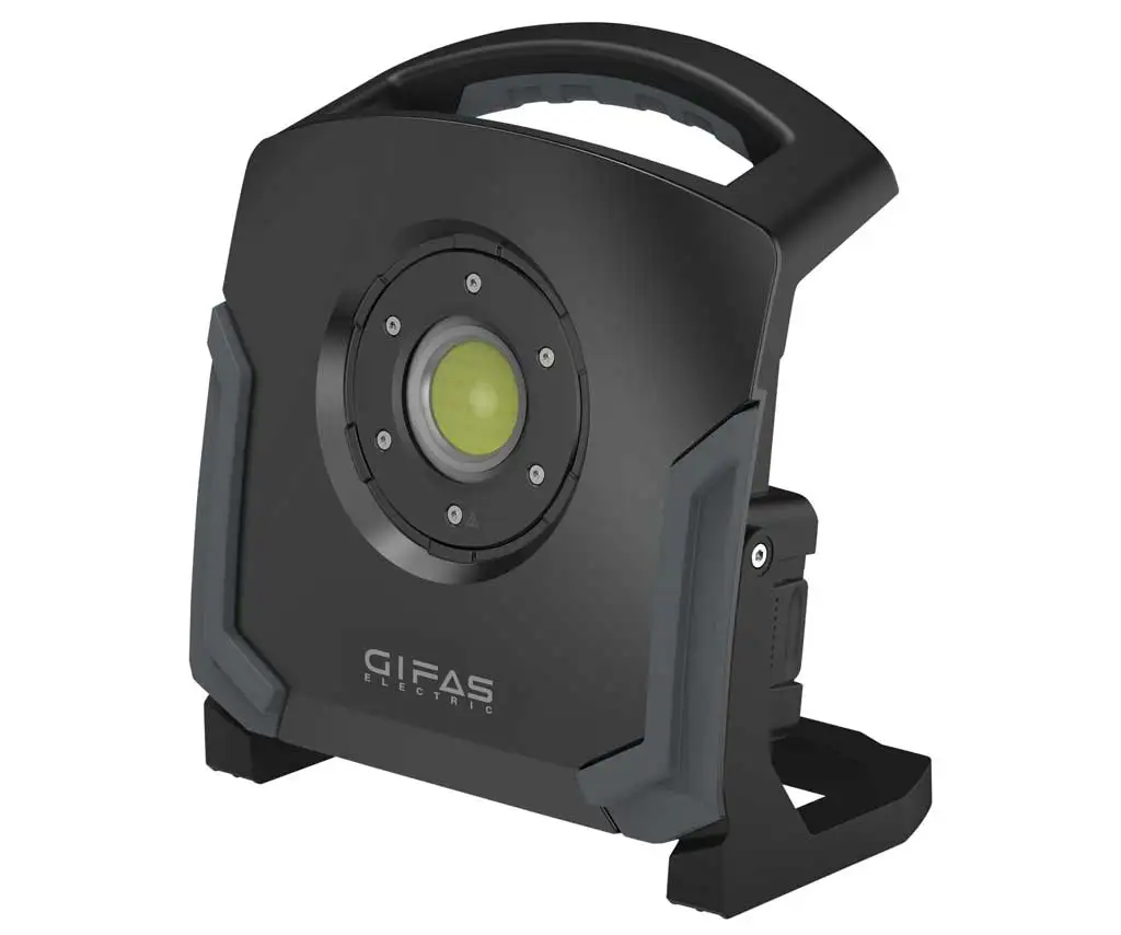 Schwarze Arbeitsleuchte mit Griff und Bügel sowie Netzanschluss und Akku-Adapter.